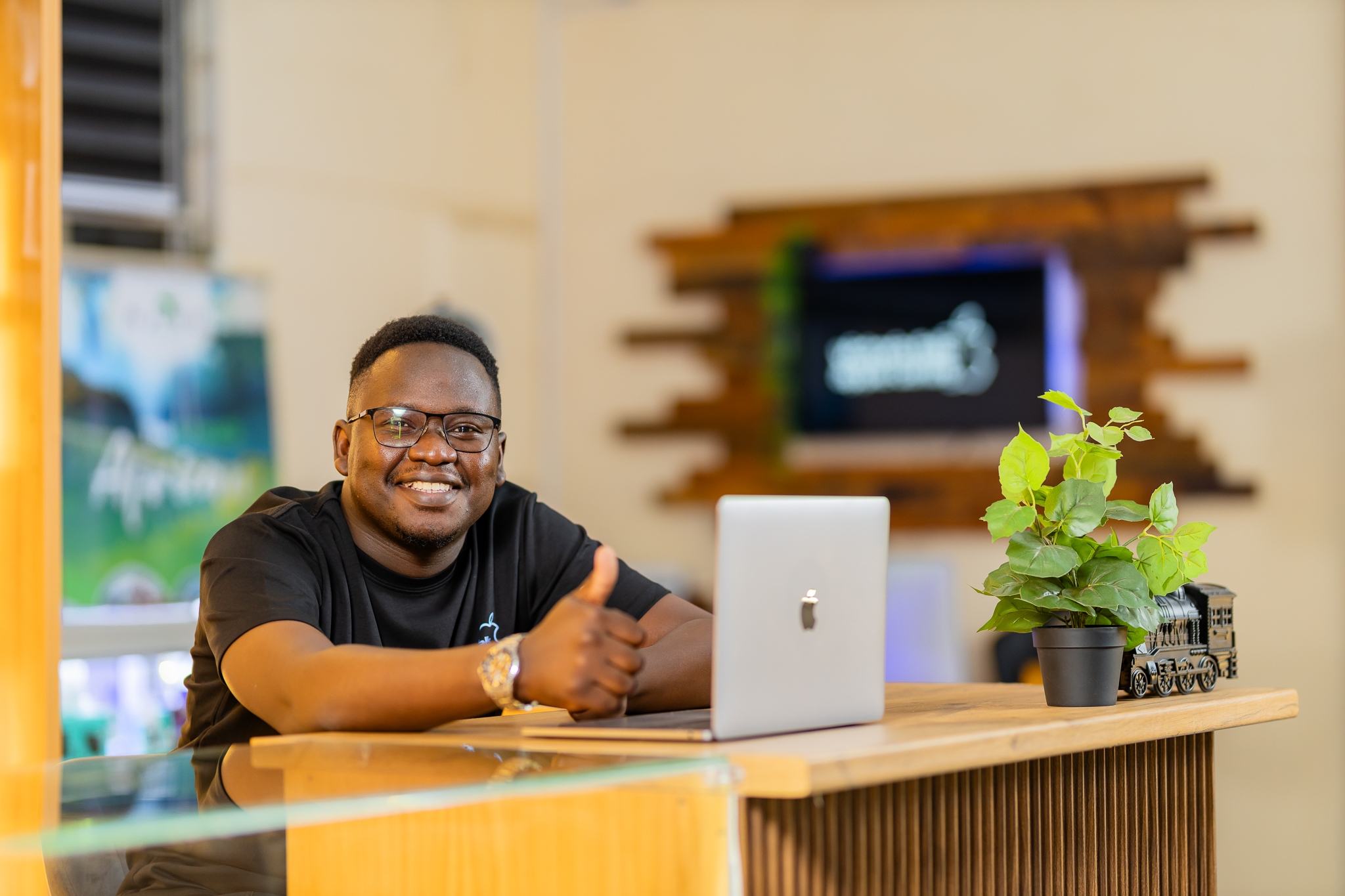 A Victoria Falls Apple Centre team member at the counter with a MacBook