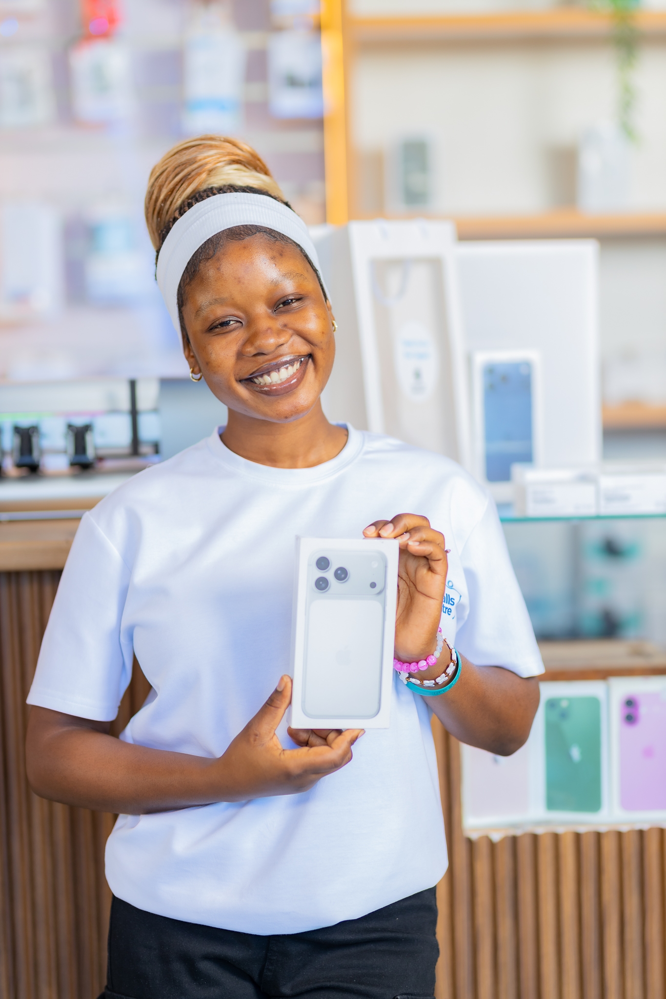 Victoria Falls Apple Centre staff member holding a new iPhone